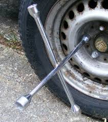 Pull down from above on the wrench with the socket on the lug nut. Lug Wrench Wikipedia