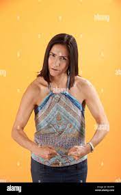 Tough Latina woman on orange background shows off her muscles Stock Photo -  Alamy