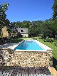La piscine à débordement fait toujours rêver ! Le Debordement Par L Esprit Piscine 9 X 3 M Revetement Gris Clair Margelles En Pierre Naturelle De Veze Mur De Deb Piscine Muret Piscine Piscines Design