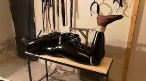 Crossdresser bondage hogtied in catsuit gagged and hooded