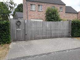 vergrijsde padouk schuifpoort houten poorten houten hek tuin poorten
