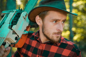 Forest Farmer As A Forest Worker At The Tree Fell In The Forest Chainsaw  Man Working