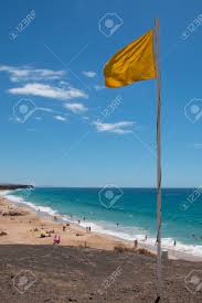 This could mean it's a rough day out in the waves, there's large waves, or there may. Yellow Flag On The Beach Means To Use Caution While Swimming Lanzarote Spain Vertical Shot Lifeguard Or Safety Icon Stock Photo Picture And Royalty Free Image Image 96690544