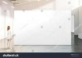 Woman Walking Near Blank White Wall Mockup In Modern Gallery Girl Admires A Clear Big Stand Mock Up In Museum With Conte White Walls Hall Interior Blank White