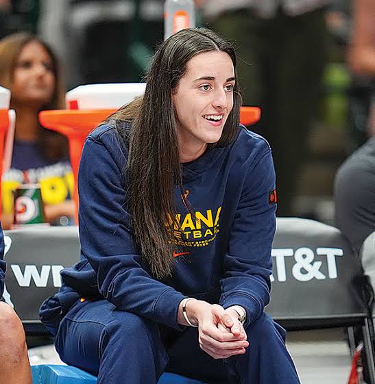 Caitlin Clark observing from the sideline bench, do AI tạo