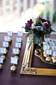 Use a large ornate gilded frame covered in flowers and pin the escort cards into the bed of flowers for a beautiful statement. Gourmet Chocolate Wedding Favors Chocolate Wedding Favors Candy Wedding Favors Wedding Name Cards