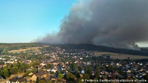 Emergency services and fire crews responding to a large wildfire in a wooded area near the German-Belgian border.