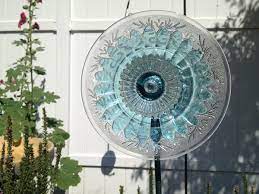 Margaret‎ combined two of our favorite garden art techniques, the barnwood bloom, where you attach objects to weathered wood to make a flower and the dish flower, where a glass plate is mounted on a rod and placed in a garden bed. How To Make Inexpensive Flower Plate Garden Art Business 2 Community