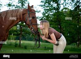 Jolie femme donnant son cheval un baiser Photo Stock - Alamy