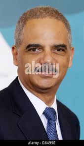 U.S. Attorney General Eric Holder, right, points to U.S. Attorney in the  Eastern District of Louisiana Kenneth Polite, Jr. at Polite's investiture  ceremony at Cohen College Prep High School in New Orleans,