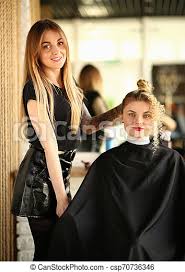 Caitlin's blonde are the most vibrant and natural. Blonde Hairstylist And Curly Hair Female Client Beautiful Hairdresser Styling Wavy Strand And Bun For Young Woman Two In Canstock