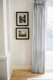 A novel way of hanging your hallway pictures is to install a curtain rod on one wall. How High To Hang Pictures According To An Interior Designer
