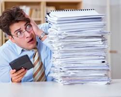 Image of someone looking stressed at tax forms