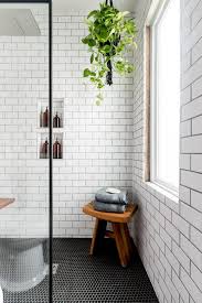 This minimalist bathroom features concrete floors and walls, a frameless mirror, and brass shower fixtures. Black And White Industrial Bathroom Cherished Bliss