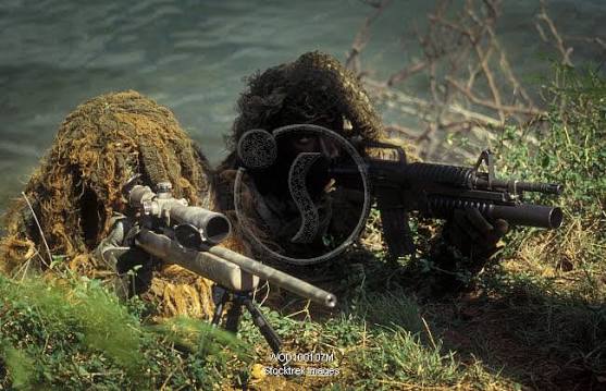 A SEAL Sniper swim pair set up an observation post. | Stocktrek Images