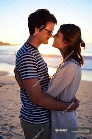 He is giving his wife a piggyback. Romantic Couple On The Beach At Sunset Standing Joy Stock Photo 265159208