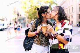 Young lesbian couple holding ice cream while kissing on street in city,  Stock Photo, Picture And Royalty Free Image. Pic. WES-DGOF01616 |  agefotostock