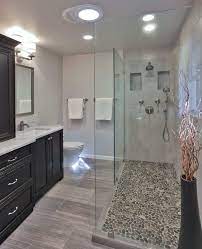 As this example shows, the addition of a curbless shower allows for a bigger floor space and an overall sense of volume in the bathroom. Awesome Bathroom With Walk In Shower Featured Wall Niches And Pebble Shower Flooring Bathro Bathrooms Remodel Bathroom Design Bathroom Recessed Lighting