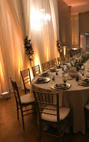 Backdrop With Crystal Chandelier And Up Lighting Behind A Round Ended Kings Table Rent Tables And Chairs Furniture Chair Chiavari Chairs