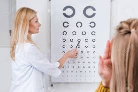 patient and optician doing eye test with eye chart in clinic