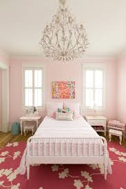 Feminine pink girl's bedroom boasts pink walls painted in sherwin williams bella pink and complemented with green decorate plates mounted above a pink tufted arch headboard complementing pink and aqua bedding accented with a patchwork quilt, pink and aqua border pillows, and an aqua. Pastel Pink Room Paint