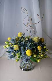 A Unique Centerpiece Of Yellow Craspedia Billy Balls And Blue Thistle Accented With Yellow Hype Unique Centerpieces Wedding Centerpieces Beautiful Centerpieces