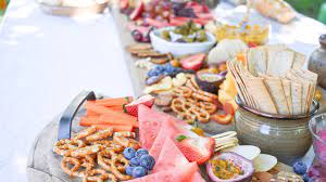 A grazing table is a tablescape filled with artfully arranged meats, cheese, crudité, as well as seasonal fruit, flowers, decorations and serving utensils and dishes. How To Style A Grazing Table Sheknows