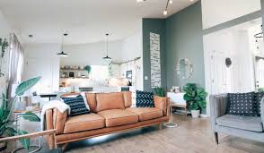 Grey living room with hints of orange from the pillows, glass decors, and hardwood flooring. Luxury Grey And Orange Living Room Ideas