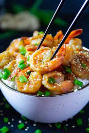 Garlic Ginger Shrimp With Green Onion And Sesame Seeds On Top In A White Bowl With Black Chop Sticks Picking Up The Shrim Seafood Recipes Asian Recipes Recipes
