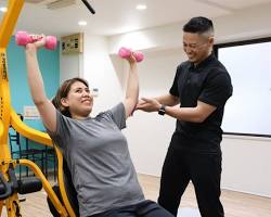 パーソナルトレーナーが笑顔で励ましている様子の画像