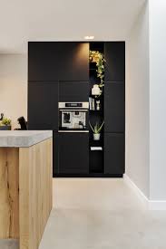 een zwarte wandopstelling met open vakken van plaatstaal het keukenblad is van arpa fenix hier in dunne solid uitvoering woonideeen interieur keuken ontwerp