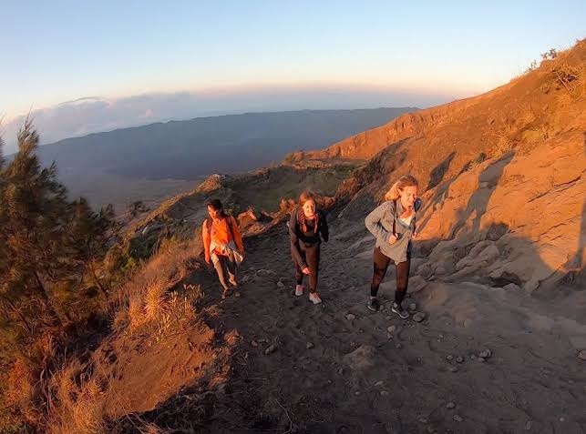The iconic Mount Batur sunrise hike leaves shoes caked in fine volcanic ash and mud., AI generated