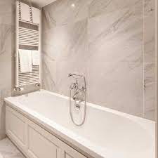 The marble is white with gray veining while the floor is black tile. Carrara Marble Tiles Natural Stone Consulting