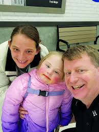 DOUG VANWORMER . . . a Frankenmuth Fire Department captain, participated in  the annual “Shop with a Hero” program December 9 at Meijer Store, Birch  Run. Pictured, he poses with a mother