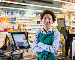 Image of teenager working at a grocery store checkout