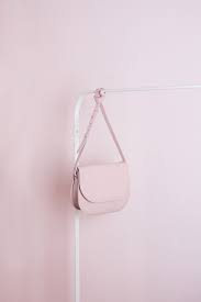 A Simple Product Photograph In Monochrome Featuring A Pink Leather Cross Body Bag And A Pink Background Fashion Inspiration Outfit Tas Objek Gambar Produk