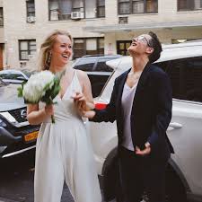 Wedding ceremony leader, masked worker keeps a social distance during the congratulations couple. Brides Throw Social Distanced Wedding On New York Street