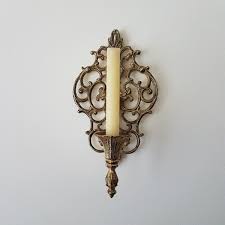 They often feature two candles on an ornate base plate. Ornate Gold Metal Candle Sconce Hollywood Regency Or Etsy Candle Holders Wall Decor Candle Wall Decor Metal Candle Sconce