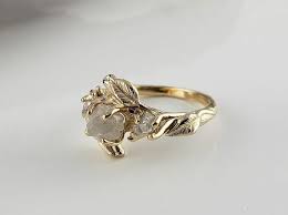 This whimsical gold setting with a raw diamond and polished diamond accents is the best of both worlds. 35 Raw Diamond Engagement Rings For A Unique Natural Vibe
