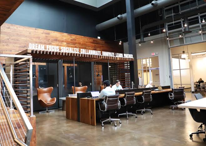 Modern coworking facility providing open desks and private meeting suites., 