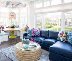 A white coastal living room with white furniture and curtains, a tan rug and a suspended ship. Beach Themed Living Rooms Sugars Beach 2021
