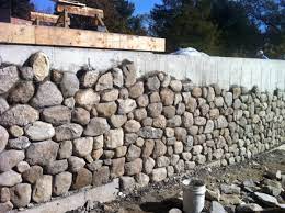 Covering Cement Wall With Stone Veneer For Our Lovely Retaining Wall Along The Driveway Diy House Foun Stone Wall Design Covering Cement Walls Retaining Wall