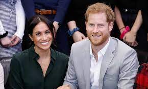 Harry looks lovingly at meghan, who cradles her baby bump as she rests in his lap. 3rqoz1nigeq M