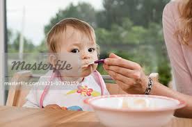 Mother Feeding 1 Year Old Baby Girl Eating Stock Photo