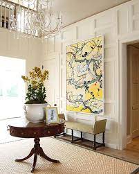 A smaller entryway table with a large mirror and one large vase filled with flowers is a simple yet stunning way to make your entryway inviting. Classic Revival How To Decorate A Round Entry Table Sa Decor Design