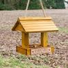 Stick earth material like moss, barks, pine cones and rocks on birdhouse. 1