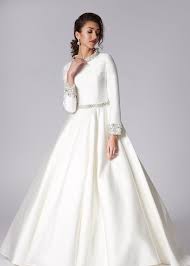 It features a wide variety of wedding gowns to suit all tastes, from charmeuse wedding dresses with embroidery to simple and minimalistic designs for a casual wedding. Elegant Yet Modest Mikado Satin Ballgown With Mandarin Collar And Sleeves