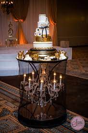 White Black And Gold Five Tier Wedding Cake On A Beautiful Black Chandelier Table Top Cake Table Decorations Wedding Cake Table Decorations Wedding Cake Table