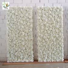The artificial flowers are connected to a plastic grid backing that is durable and bendable. China Uvg 8ft White Artificial Flower Wall With Silk Hydrangea And Rose For Wedding Decoration China Artificial Flower Wall Price