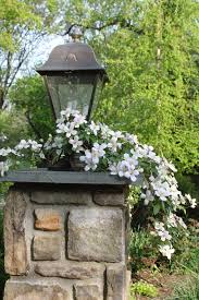 Stone Entrance With Lamp And Clematis Structure Is Very Important In Design It Invites You In With A Sens Stone Pillars White Gardens Best Outdoor Lighting